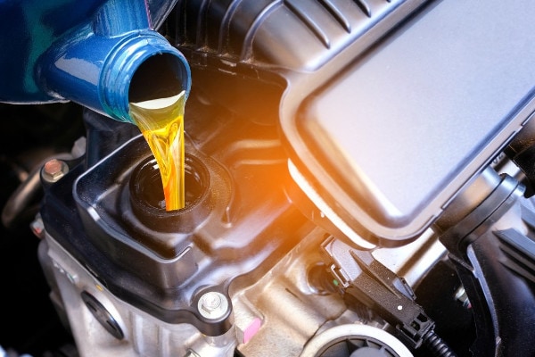 Aceite de motor vertido desde un envase azul